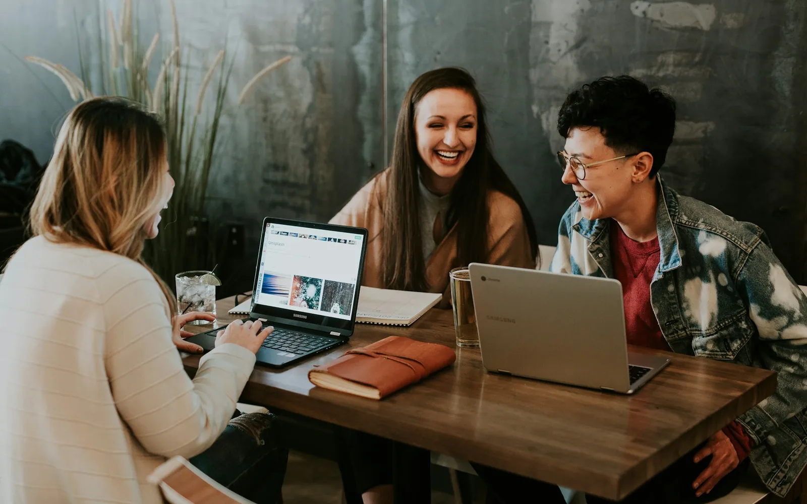 Three adults sharing ideas around a laptop.
